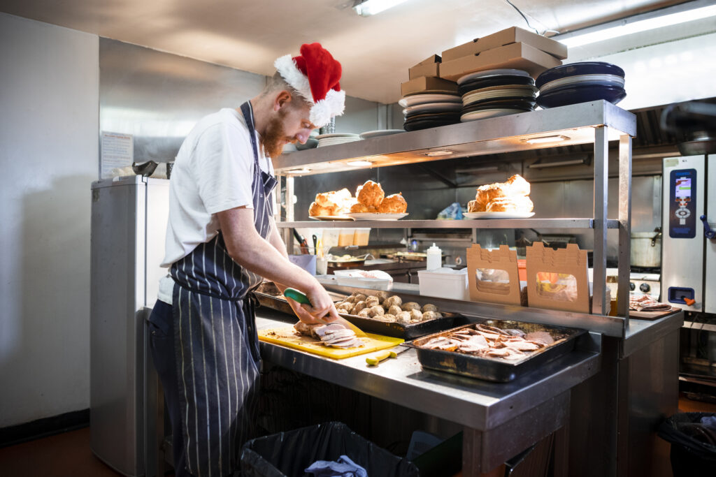 man santa hat prepping food